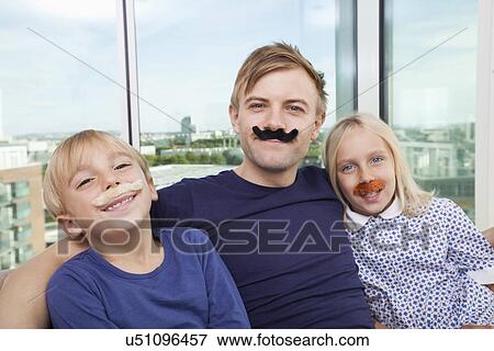 Portrait of father and children with artificial mustache at home View Large Photo Image Stock Photo - Portrait of father and children with artificial mustache at home. Fotosearch