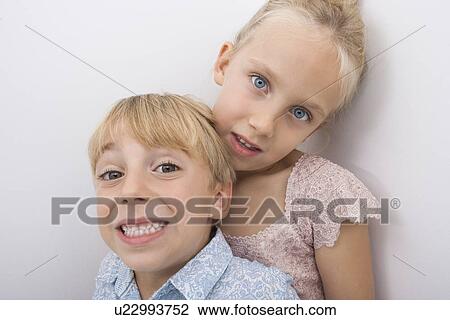 Portrait of happy brother with sister over gray background View Large Photo Image Stock Image - Portrait of happy brother with sister over gray background. Fotosearch