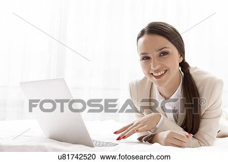 Portrait of happy businesswoman using laptop in hotel room View Large Photo Image Stock Image - Portrait of happy businesswoman using laptop in hotel room. Fotosearch
