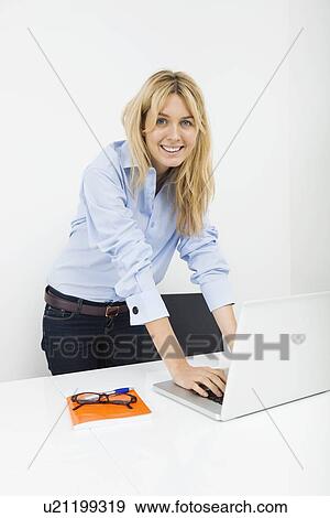 Portrait of happy businesswoman using laptop in office View Large Photo Image Stock Photo - Portrait of happy businesswoman using laptop in office. Fotosearch