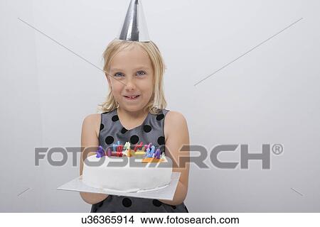 Portrait of happy girl holding birthday cake at home View Large Photo Image Picture - Portrait of happy girl holding birthday cake at home. Fotosearch