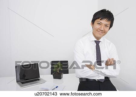 Portrait of happy mid adult businessman with arms crossed leaning on office desk View Large Photo Image Stock Image - Portrait of happy mid adult businessman with arms crossed leaning on office desk. Fotosearch