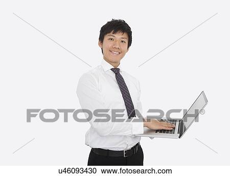 Portrait of happy mid adult businessman using laptop over white background View Large Photo Image Stock Image - Portrait of happy mid adult businessman using laptop over white background. Fotosearch