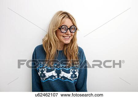 Portrait of happy woman in sweater wearing eyeglasses against white background View Large Photo Image Stock Photo - Portrait of happy woman in sweater wearing eyeglasses against white background. Fotosearch