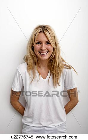 Stock Photography - Portrait of happy woman standing against white background. Fotosearch