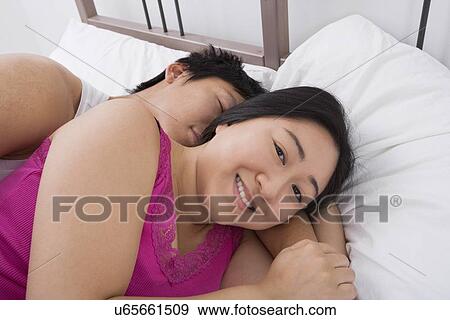 Portrait of happy woman with man sleeping in bed View Large Photo Image Stock Photo - Portrait of happy woman with man sleeping in bed. Fotosearch