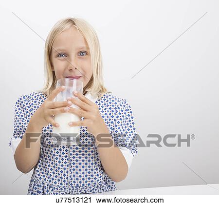 Stock Image - Portrait of little girl drinking milk. Fotosearch