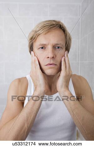 Portrait of man applying aftershave moisturizer in bathroom View Large Photo Image Picture - Portrait of man applying aftershave moisturizer in bathroom. Fotosearch