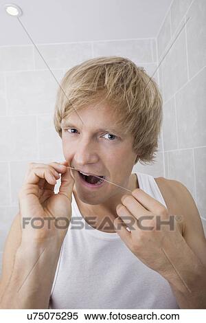 Portrait of man flossing teeth in bathroom View Large Photo Image Stock Photography - Portrait of man flossing teeth in bathroom. Fotosearch