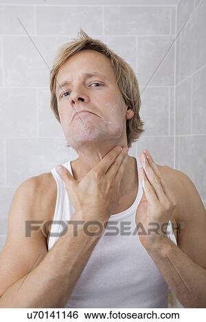 Portrait of mid-adult man applying aftershave moisturizer in bathroom View Large Photo Image Stock Photograph - Portrait of mid-adult man applying aftershave moisturizer in bathroom. Fotosearch