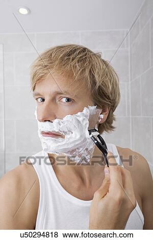 Portrait of mid-adult man shaving in bathroom View Large Photo Image Stock Photo - Portrait of mid-adult man shaving in bathroom. Fotosearch