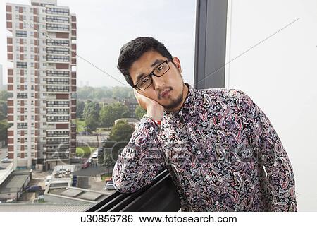 Portrait of sad man leaning on window at home View Large Photo Image Stock Photograph - Portrait of sad man leaning on window at home. Fotosearch