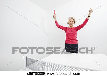 Portrait of senior female table tennis player with arms raised celebrating victory View Large Photo Image Stock Photo - Portrait of senior female table tennis player with arms raised celebrating victory. Fotosearch
