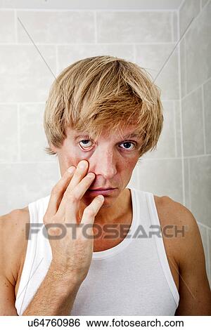 Portrait of sleepy man pulling eyelid in bathroom View Large Photo Image Stock Photograph - Portrait of sleepy man pulling eyelid in bathroom. Fotosearch
