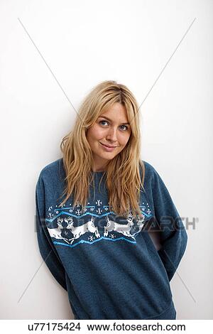 Portrait of smiling woman in sweater against white background View Large Photo Image Picture - Portrait of smiling woman in sweater against white background. Fotosearch