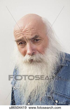 Stock Photo - Portrait of suspicious senior man over gray background. Fotosearch