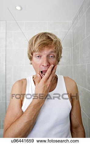 Portrait of tired man yawning in bathroom View Large Photo Image Stock Photo - Portrait of tired man yawning in bathroom. Fotosearch