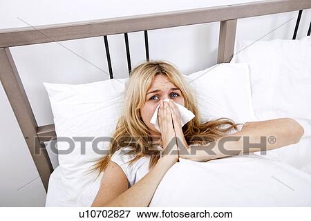 Portrait of woman suffering from cold in bed View Large Photo Image Stock Photo - Portrait of woman suffering from cold in bed. Fotosearch