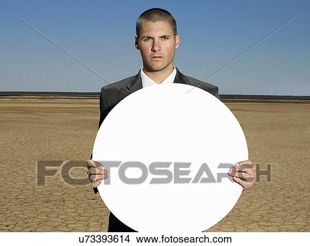 Picture - Portrait of young businessman holding blank sign. Fotosearch