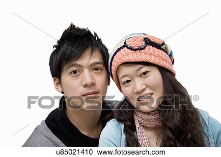 Stock Image - Portrait of young couple over white background. Fotosearch