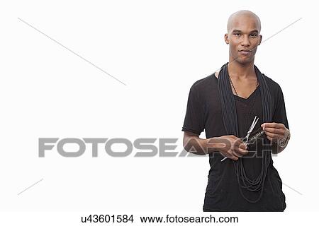 Portrait of young hairstylist standing against white background View Large Photo Image Picture - Portrait of young hairstylist standing against white background. Fotosearch