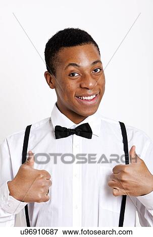 Portrait of young man gesturing thumbs up over white background View Large Photo Image Stock Photo - Portrait of young man gesturing thumbs up over white background. Fotosearch