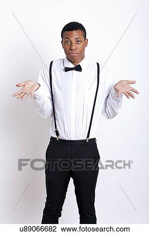 Portrait of young man shrugging against white background View Large Photo Image Stock Image - Portrait of young man shrugging against white background. Fotosearch