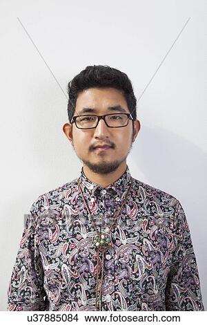 Portrait of young man wearing eyeglasses standing against white background View Large Photo Image Picture - Portrait of young man wearing eyeglasses standing against white background. Fotosearch