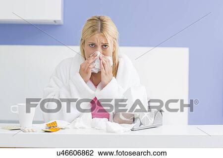 Portrait of young woman blowing nose in tissue paper View Large Photo Image Stock Image - Portrait of young woman blowing nose in tissue paper. Fotosearch
