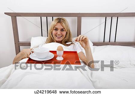 Portrait of young woman with breakfast tray in bed View Large Photo Image Stock Photo - Portrait of young woman with breakfast tray in bed. Fotosearch