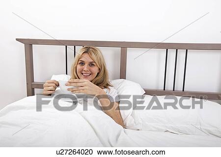 Portrait of young woman with coffee cup in bed View Large Photo Image Stock Image - Portrait of young woman with coffee cup in bed. Fotosearch