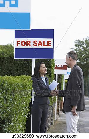 Real estate agent shaking hands with man beside for sale signs View Large Photo Image Stock Image - Real estate agent shaking hands with man beside for sale signs. Fotosearch