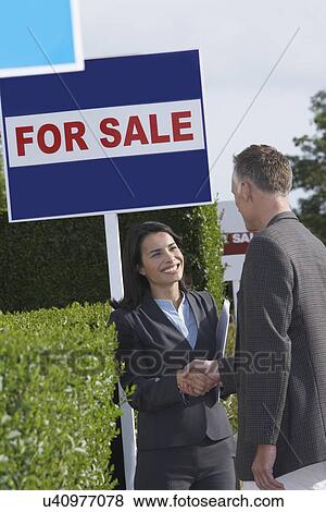 Real estate agent shaking hands with man beside for sale signs View Large Photo Image Stock Photo - Real estate agent shaking hands with man beside for sale signs. Fotosearch