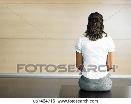 Stock Photograph - Rear view of businesswoman sitting on bench. Fotosearch