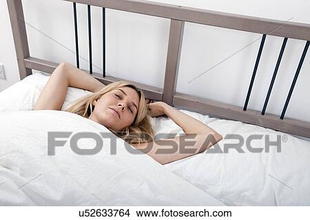 Relaxed young woman sleeping in bed View Large Photo Image Picture - Relaxed young woman sleeping in bed. Fotosearch