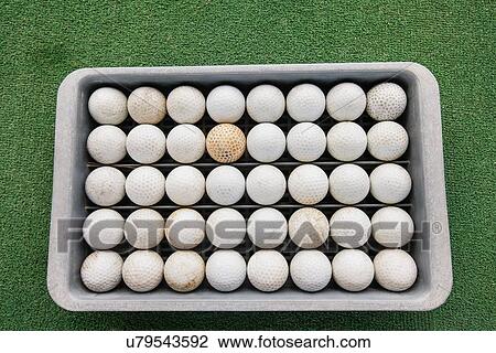 Stock Image - Rows of golf balls in tray on green, Koh Pha Ngan, Thailand. Fotosearch