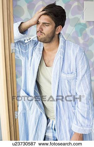 Sad man with thermometer in mouth standing by at doorway View Large Photo Image Stock Photo - Sad man with thermometer in mouth standing by at doorway. Fotosearch