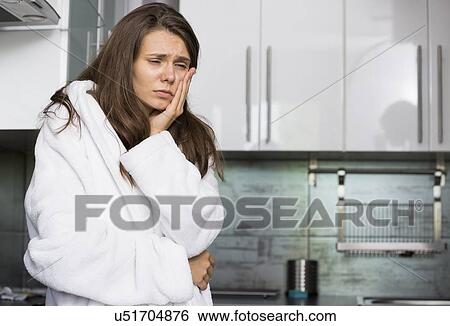 Sad woman suffering from toothache standing in kitchen View Large Photo Image Stock Photograph - Sad woman suffering from toothache standing in kitchen. Fotosearch