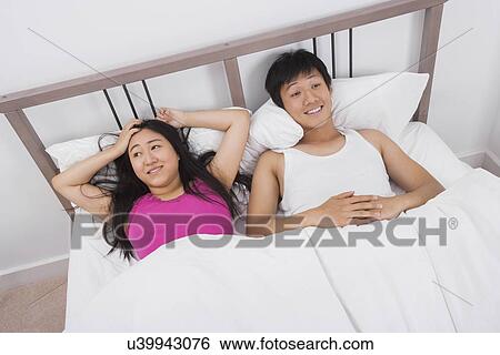 Satisfied young couple in bed View Large Photo Image Stock Photograph - Satisfied young couple in bed. Fotosearch