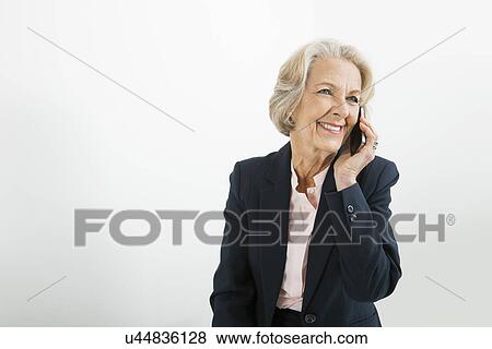 Stock Photo - Senior businesswoman using cell phone in office. Fotosearch