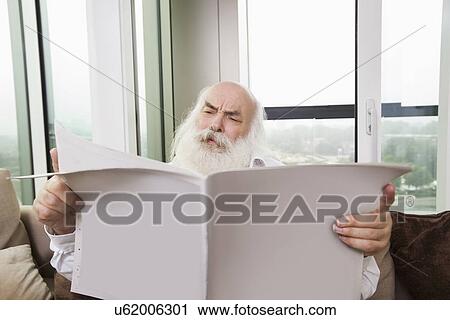 Senior man reading newspaper in house View Large Photo Image Stock Image - Senior man reading newspaper in house. Fotosearch