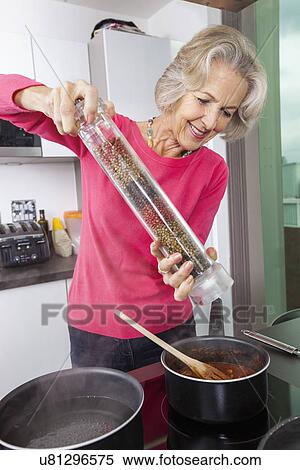 Senior woman cooking food using pepper grinder View Large Photo Image Stock Photography - Senior woman cooking food using pepper grinder. Fotosearch