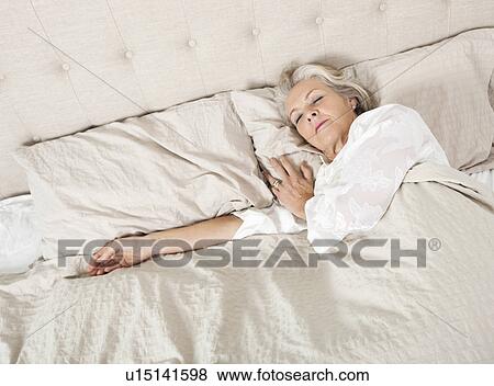 Stock Photo - Senior woman sleeping in bed. Fotosearch