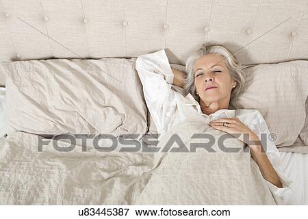 Senior woman sleeping in bed View Large Photo Image Stock Photo - Senior woman sleeping in bed. Fotosearch