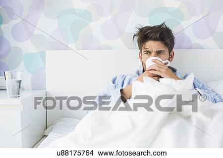Picture - Sick man having coffee in bed. Fotosearch