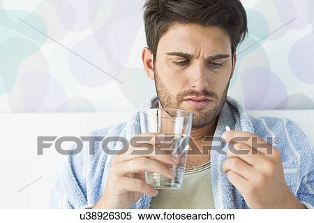 Sick man taking medicine in bedroom at home View Large Photo Image Stock Photography - Sick man taking medicine in bedroom at home. Fotosearch