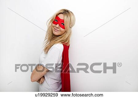 Side View Portrait Of Confident Woman In Superhero Against White
