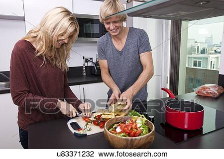 Smiling Caucasian couple cooking together in kitchen View Large Photo Image Stock Image - Smiling Caucasian couple cooking together in kitchen. Fotosearch