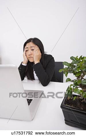 Stressed businesswoman looking at laptop in office View Large Photo Image Stock Image - Stressed businesswoman looking at laptop in office. Fotosearch