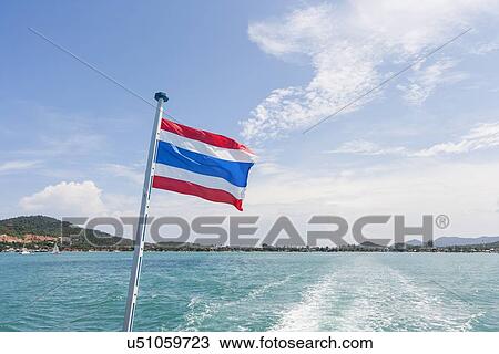 Stock Image - Thailand flag with boat wake at Koh Pha Ngan island. Fotosearch
